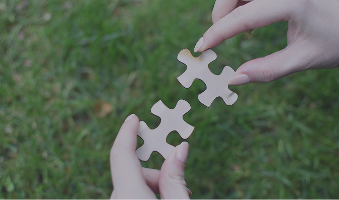 Zwei Hände geben sich das passende Puzzlestück – Symbol für erfolgreiche Kooperation und B2B-Partnerschaft in der Tech-Beratung